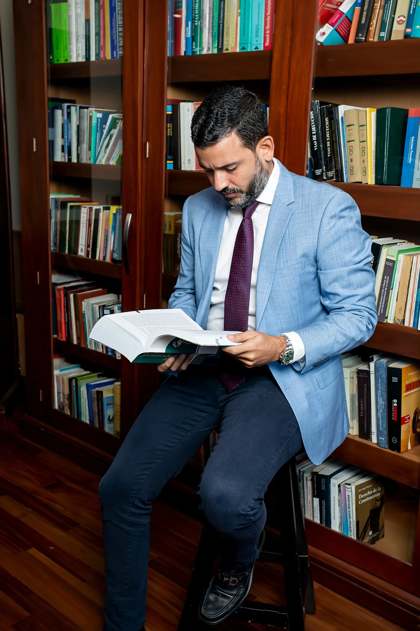 Abogado del estudio consultando un volumen en la biblioteca jurídica de la firma